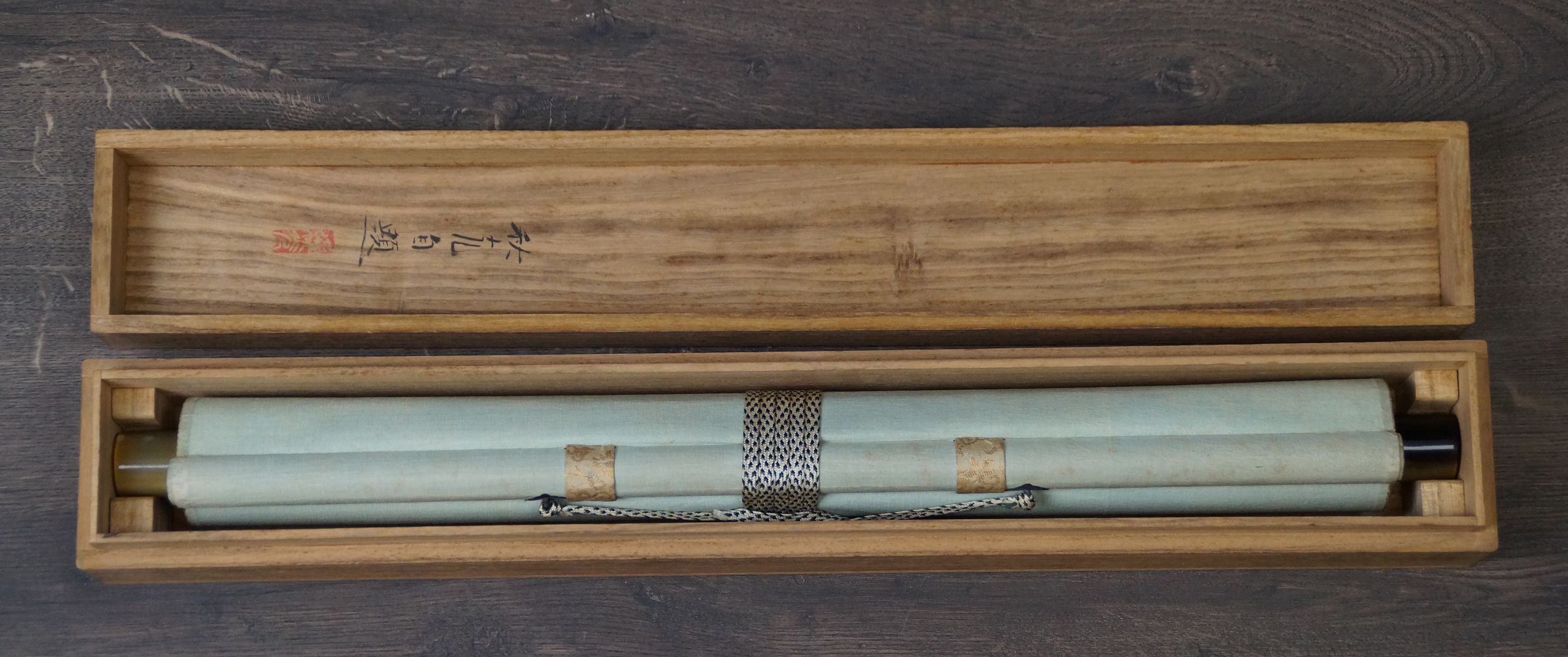 Zusammengerolltes Kakemono Nachtigall auf bluehendem Pflaumenast in der geoeffneten Aufbewahrungsbox