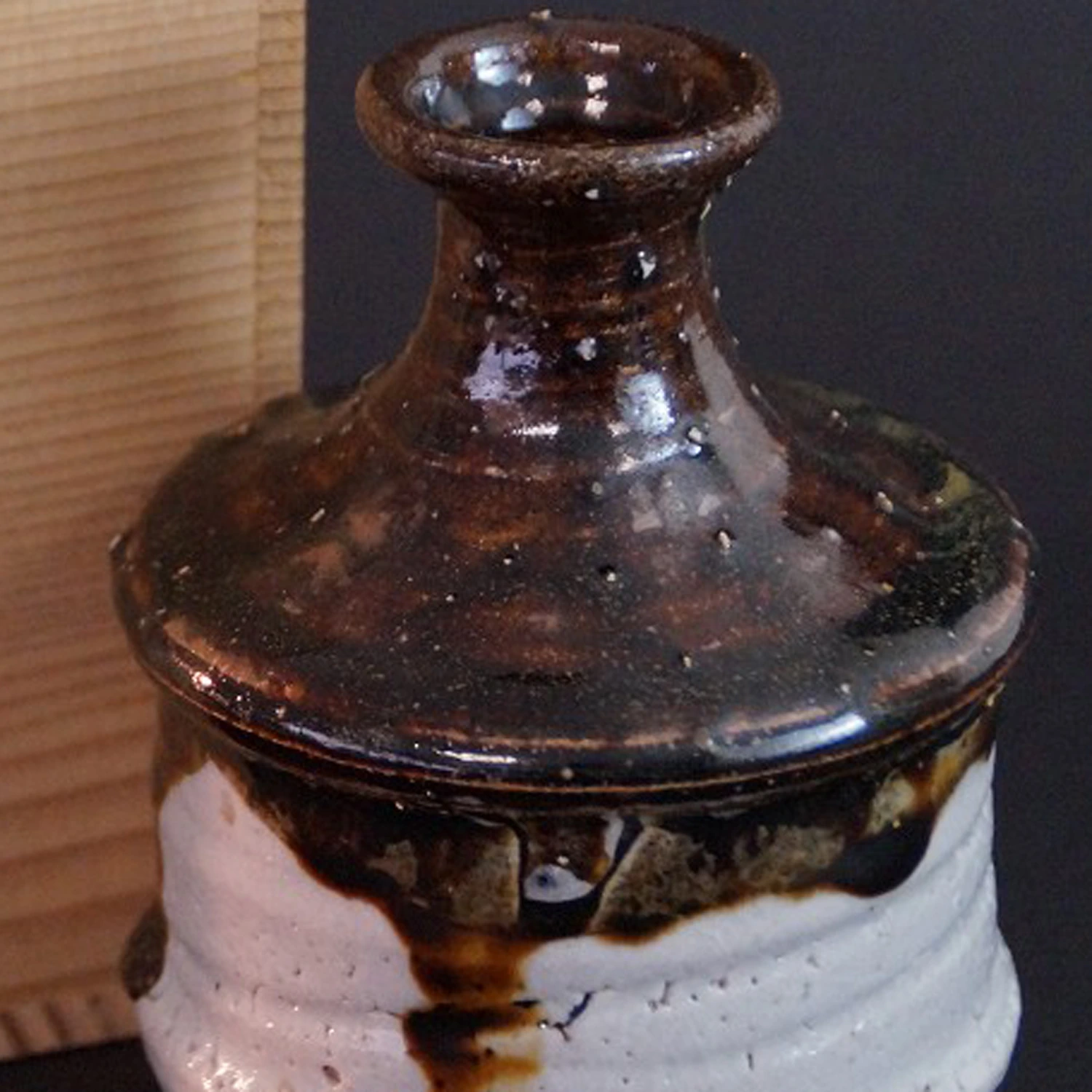 Anteprima primo piano della bottiglia da sake di Karatsu con scatola di conservazione sullo sfondo