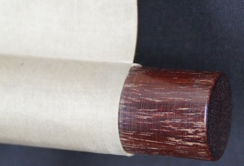 Vista dettagliata dell'estremità del rotolo con pomello in legno rosso scuro e seta color crema del kakemono Fuji tra le vette avvolte dalle nuvole