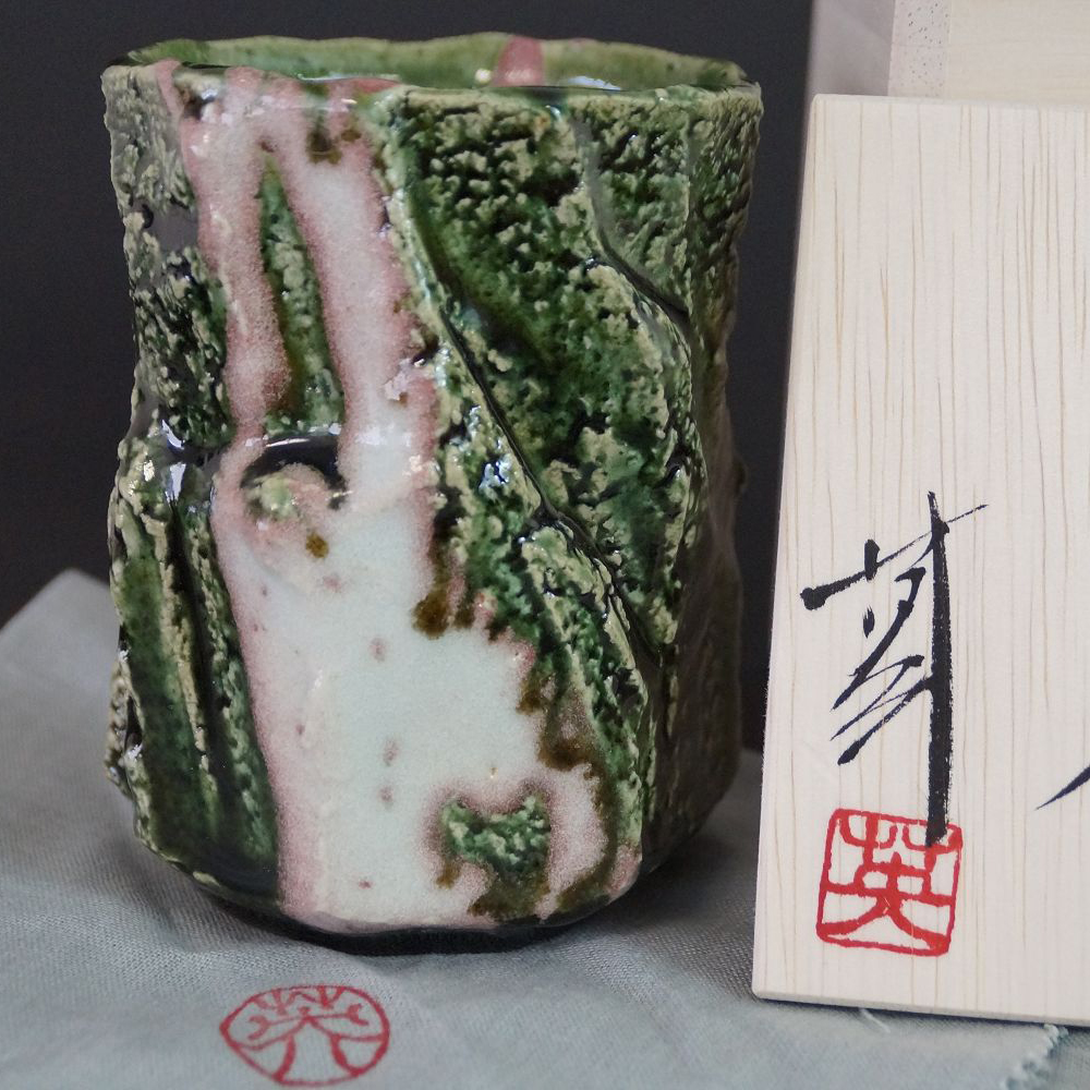 Yunomi Tee-Schale aus Oribe-Keramik von Kawachi Hidetoshi in der Gesamtansicht mit gruen-rosa-weiss gemusterter Glasur
