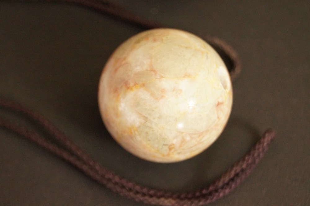 Gruenlich beige gemaserte Steinkugel mit Kordel Stein-Nahaufnahme 3