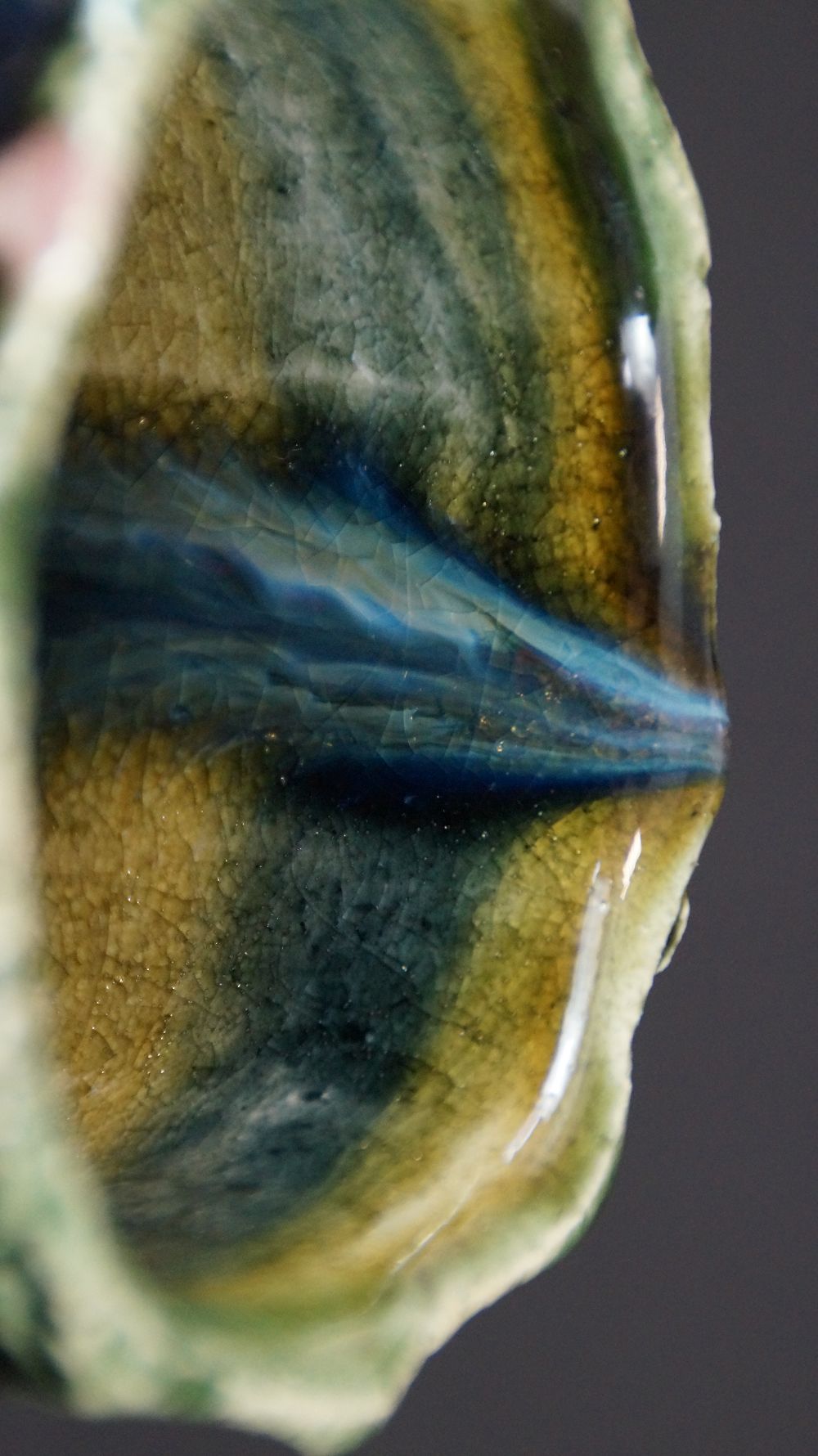 Nahaufnahme der gestreiften gelb-gruen-blauen Innenglasur der Yunomi Tee-Schale aus Oribe-Keramik