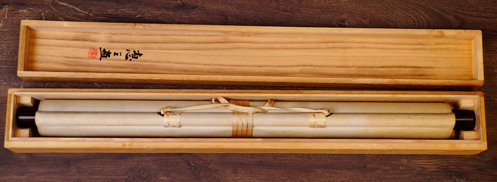 Zusammengerolltes und mit Kordel verschnuertes Kakemono Die Vier Edlen Pflanzen von Endo Keizo in der geoeffneten Aufbewahrungsbox
